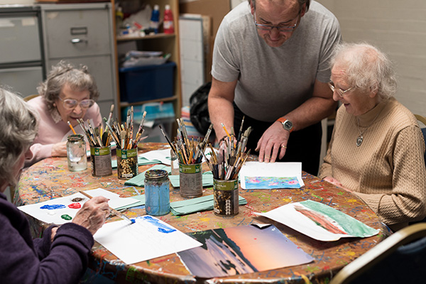 Three service users at Fred Paton Day Care Centre enjoy an art class